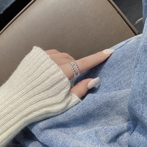 Close-up of double-layer silver beaded ring on finger with casual denim background