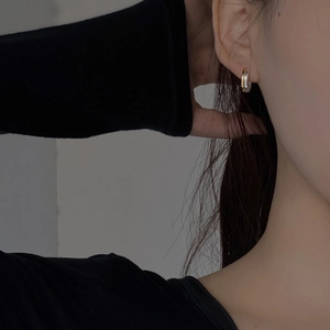 Close-up of elegant gold and silver contrast metal hoop earrings on female model