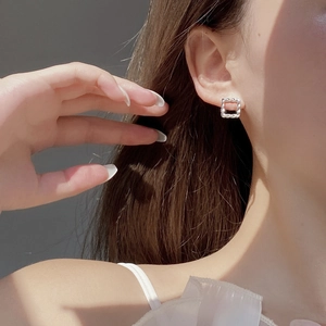 Close-up of S925 sterling silver square twist stud earring on model's ear