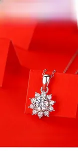 Détail du pendentif tournesol en argent 925 avec moissanite brillante sur fond rouge