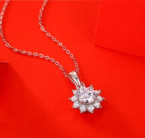 Macro d'un pendentif tournesol en argent 925 avec moissanite étincelante sur fond rouge vif