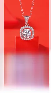 Macro shot of silver Moissanite pendant with halo setting on red geometric prop