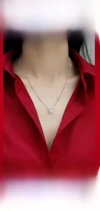 Moissanite pendant necklace on model with red blouse showing elegant layered style