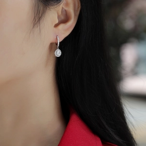 Orecchini a goccia halo in argento S925 con moissanite indossati da una modella