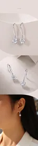 Macro detail of S925 silver long drop earrings with six-prong moissanite setting