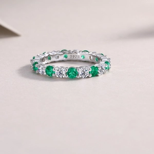 Macro shot of S925 sterling silver stamp on eternity ring with green and white gemstones