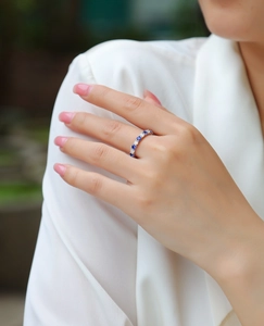 Close-up of S925 silver ring with alternating blue sapphires and clear diamonds on model