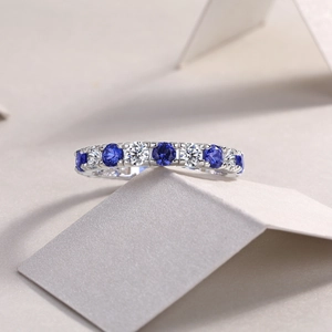 Vue macro d'une bague en argent S925 sertie de saphirs bleus et blancs alternés