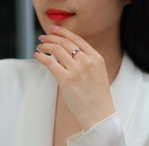 Vue détaillée d'une bague en argent S925 avec rubis rouges et diamants blancs à la main