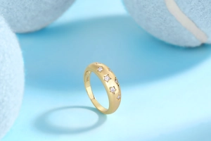 Detail of gold S925 silver ring featuring star patterns and inlaid moissanite stones