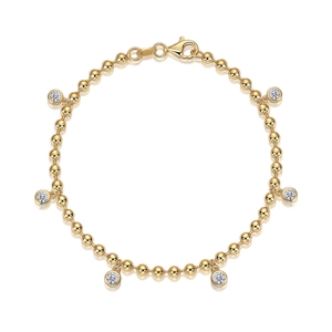 Golden beaded chain bracelet with six round cut clear stones on a white background