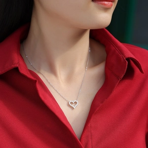 Elegant S925 silver heart pendant necklace with sparkling stones on a red background
