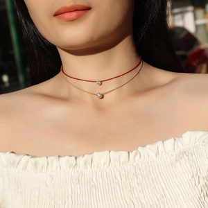 Collana doppia minimalista in oro e filo rosso con due brillanti ciondoli in moissanite