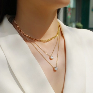 Gouden ketting met drie lagen met platte hoefijzerketting en ronde zirkonia hangers
