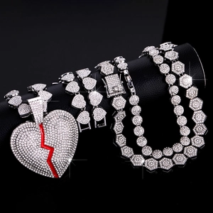 Nahaufnahme von Iced Out Herzanhänger mit rotem Riss auf schwarzem Lederhintergrund