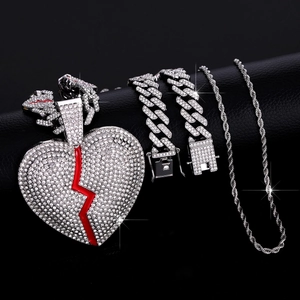 Dettaglio ciondolo a cuore spezzato con catena cubana ghiacciata e collana intrecciata