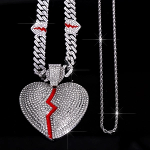 Dettaglio del ciondolo a cuore spezzato hip hop con zirconi e catene a maglia cubana