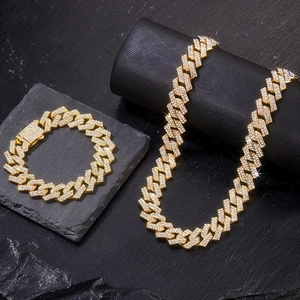 Gold 15mm Miami Cuban link chain set with full pave CZ stones on a dark textured surface