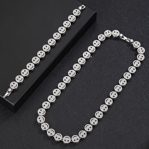 Silver iced-out smiley face Cuban link necklace and bracelet jewelry set on black background