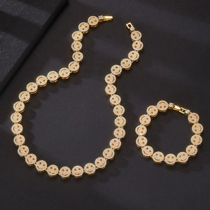 Macro shot of 12mm gold cuban link necklace and bracelet set with iced out smiley faces