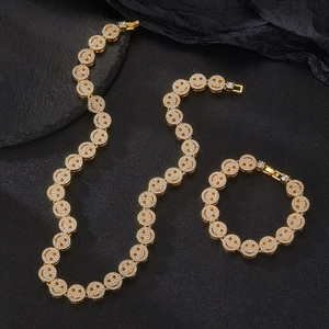 Macro shot of 12mm gold-plated Cuban chain jewelry set with pave crystal smiley faces