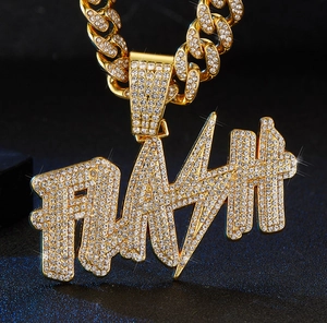 Macro shot of gold-plated FLASH pendant with cubic zirconia on heavy Cuban link chain