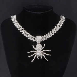 Detailed close-up of a hip hop spider pendant with iced out crystals on a cuban link chain