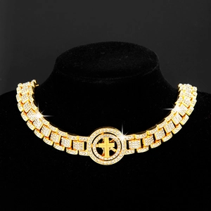 Close-up of hip-hop gold chain with iced-out cross pendant on black jewelry stand