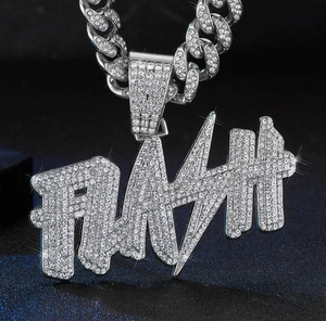 Close-up of iced out FLASH letter pendant and Cuban link chain with sparkling crystals