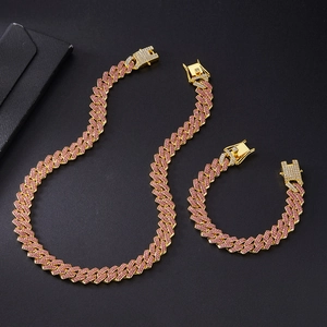 Detail of 14mm gold Cuban link necklace and bracelet set with pink iced out diamonds