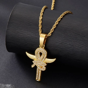 Macro detail of Eye of Horus Ankh cross pendant with sparkling crystals on gold twist chain