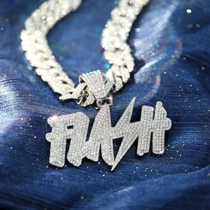 Macro detail of silver hip-hop Cuban link chain with FLASH iced-out pendant