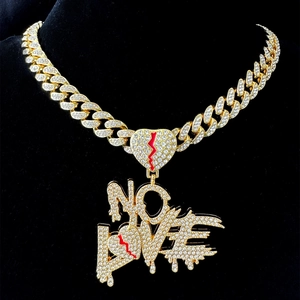 Detail of gold Cuban chain necklace with iced-out No Love heart pendant and red lightning
