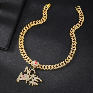 Close-up of gold cuban chain necklace with iced out No Love broken heart pendant
