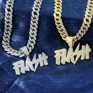 Iced out gold and silver Cuban link chains with FLASH letter pendants on blue glitter fabric