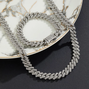 Gros plan sur l'ensemble de bijoux chaîne cubaine argentée de 11 mm avec strass sur marbre