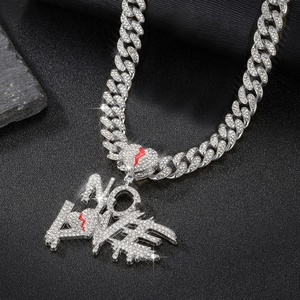 Macro view of iced out NO LOVE letter pendant with Cuban link chain and rhinestones