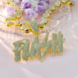 Detailed close-up of golden iced out FLASH letter pendant and sparkling chain