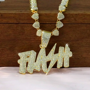 Macro detail of gold Cuban chain heart links and sparkling FLASH letter iced out pendant