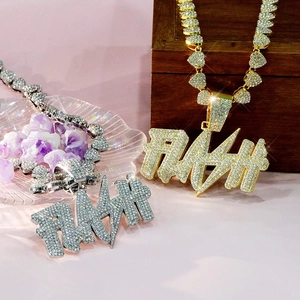 Detail of gold and silver FLASH hip hop pendants with heart-shaped chain on display
