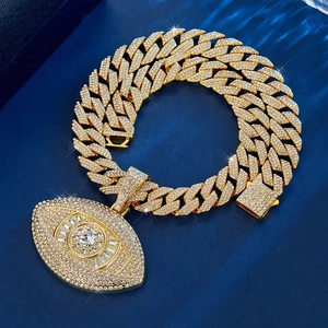 Macro shot of Cuban link chain with gold Evil Eye pendant encrusted in shimmering diamonds