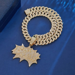 Detailed macro view of the gold iced-out Cuban chain and BOOM! pendant set