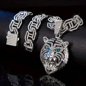 Dettaglio della collana con ciondolo a testa di tigre e bracciale hip hop d'argento