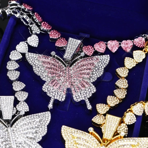 Gros plan du pendentif papillon avec chaîne à cœurs sertie de diamants en plusieurs couleurs