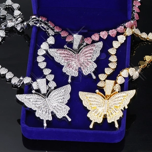 Détail de pendentifs papillon avec strass étincelants et chaîne à maillons en cœur