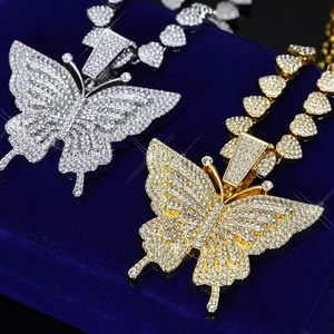 Vue détaillée des pendentifs papillon avec zircons incrustés en finition or et argent