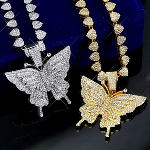 Gros plan de pendentifs papillon dorés et argentés avec chaînes cœur et strass pavés