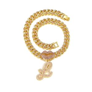 Macro shot of hip-hop cuban link chain with pink rhinestone lips and letter L pendant