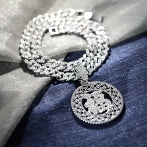 Silver Cuban chain with iced-out Fu character pendant set on luxury satin backdrop