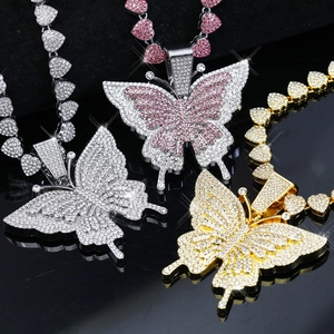 Vue détaillée de trois colliers papillon surdimensionnés en strass argentés, roses et dorés